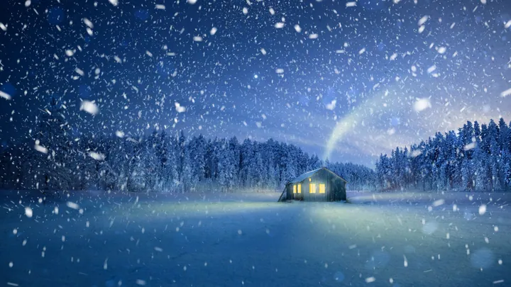 A cabin in the middle of a snowy field at night, illuminated by the lights of the house and surrounded by trees