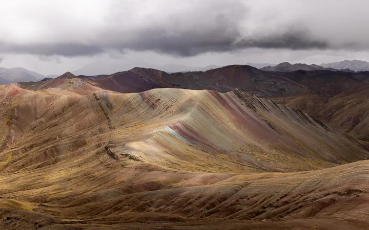 A stunning view of the rainbow mountain range in Peru, with its vibrant colors of red, orange, yellow, green, blue, and purple standing out against th