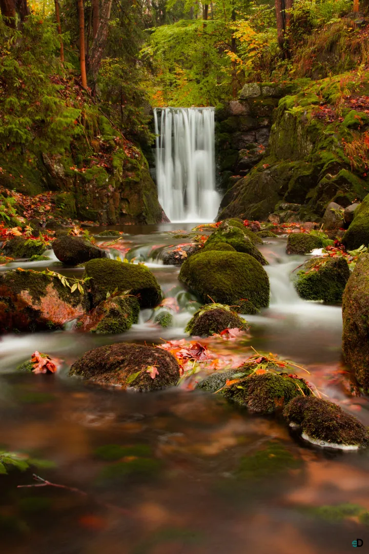 Autumn Waterfall Cascading Over Dark Stones wallpapers