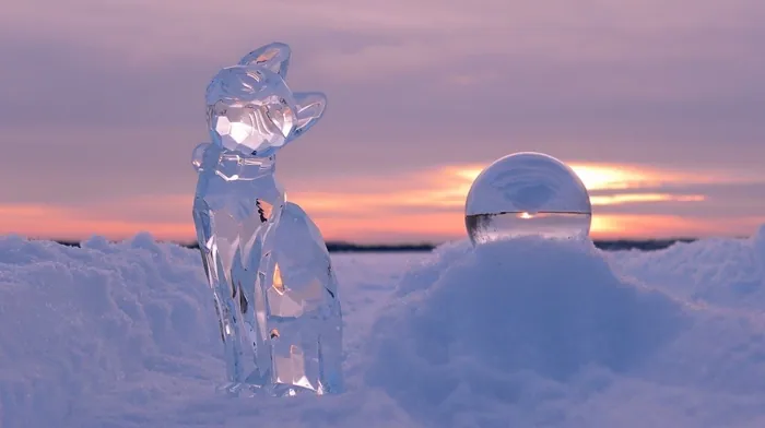 Ice Cat Sculpture On Snowy Field At Sunset wallpapers